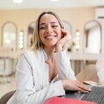 Young Female Beautician Making An Appointment Using A Laptop At A Beauty Salon